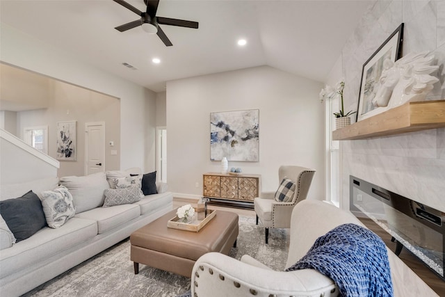 living area featuring a fireplace, lofted ceiling, recessed lighting, visible vents, and wood finished floors