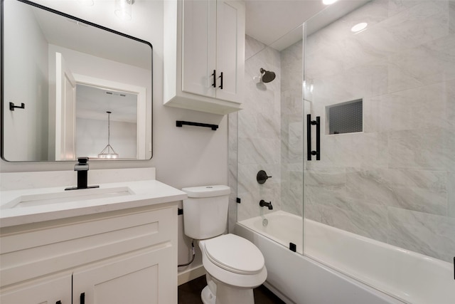 full bathroom featuring toilet, combined bath / shower with glass door, and vanity