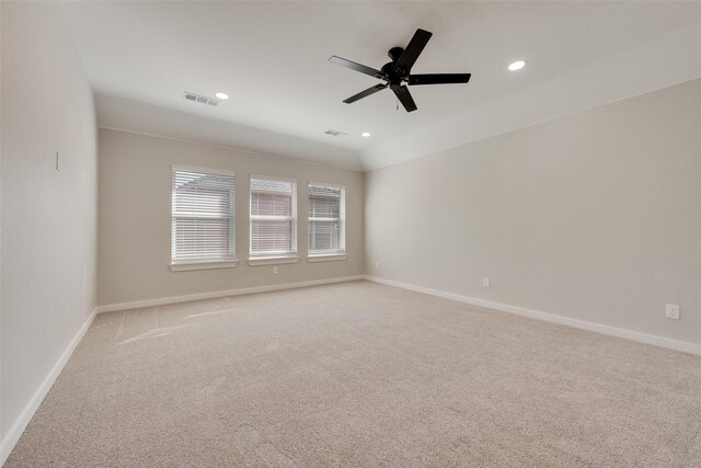 carpeted spare room featuring ceiling fan and lofted ceiling