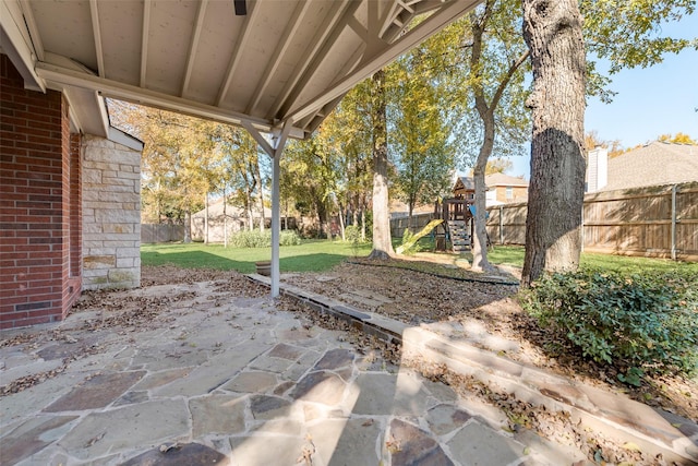 view of patio / terrace with a playground and a fenced backyard