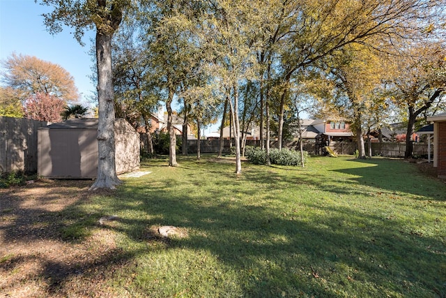 view of yard with a fenced backyard, an outdoor structure, and a storage shed