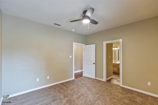 unfurnished bedroom with ceiling fan, light carpet, and connected bathroom