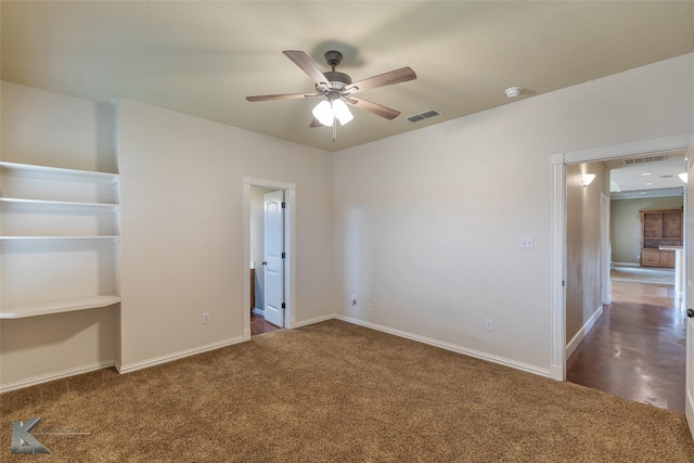 empty room with ceiling fan and dark colored carpet