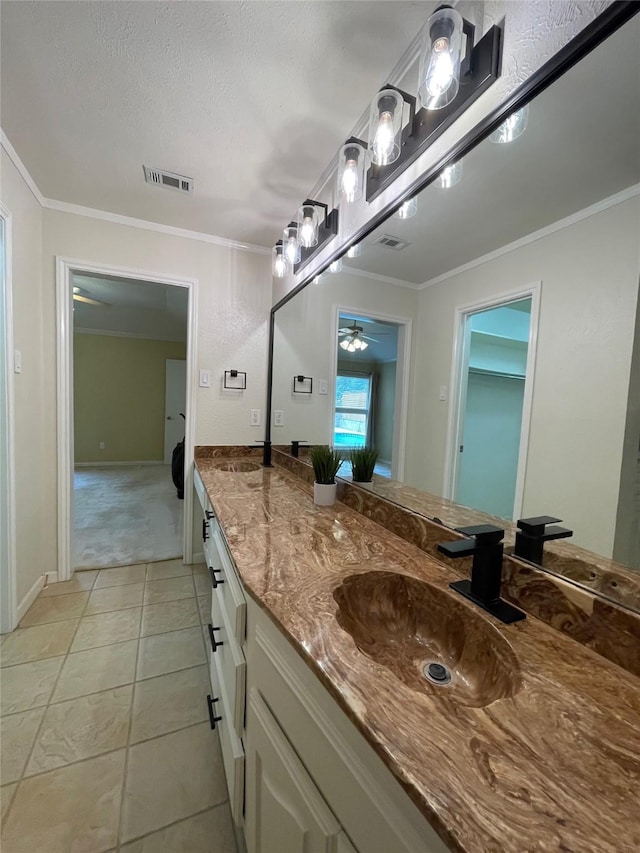 bathroom with vanity, crown molding, tile patterned flooring, ceiling fan, and a textured ceiling