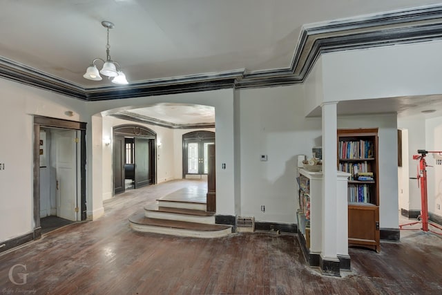 hallway with a chandelier, crown molding, and dark wood-type flooring