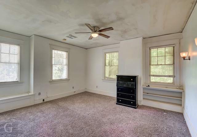 unfurnished bedroom with light colored carpet, multiple windows, and ceiling fan