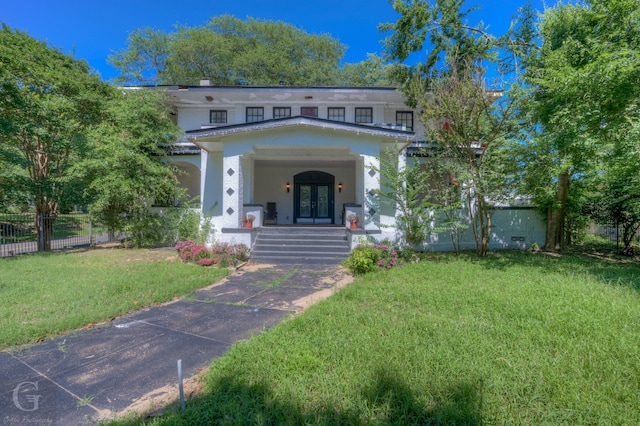 view of front of home with a front yard and french doors