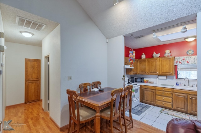 kitchen with white range with electric cooktop, sink, a textured ceiling, and light hardwood / wood-style flooring