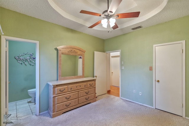 carpeted bedroom featuring ceiling fan, a raised ceiling, and a textured ceiling