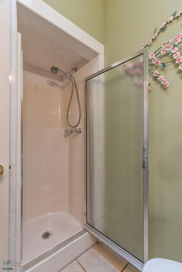 bathroom with tile patterned flooring and a shower with shower door