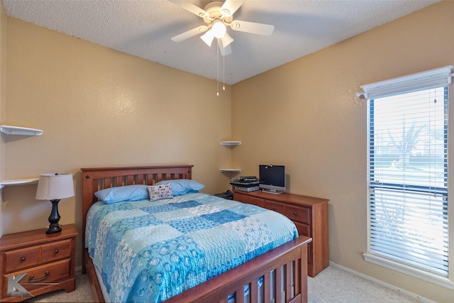 carpeted bedroom with ceiling fan and a textured ceiling