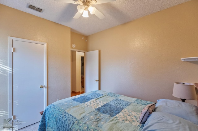 bedroom with ceiling fan and a textured ceiling