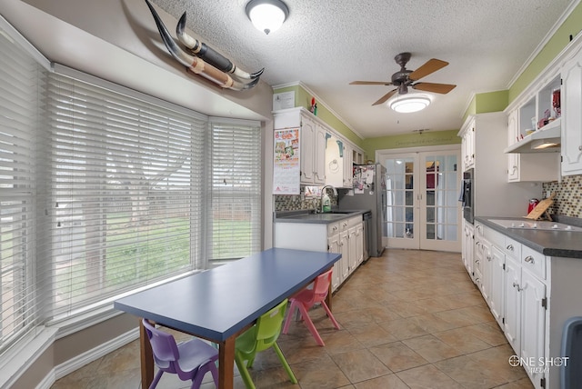 kitchen with french doors, white cabinets, sink, decorative backsplash, and light tile patterned flooring