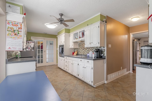 kitchen with french doors, white cabinets, ceiling fan, stainless steel fridge, and light tile patterned floors