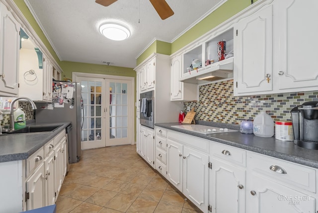 kitchen featuring electric cooktop, white cabinetry, and decorative backsplash