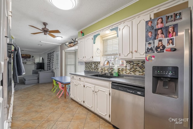 kitchen featuring white cabinetry, sink, tasteful backsplash, a textured ceiling, and appliances with stainless steel finishes