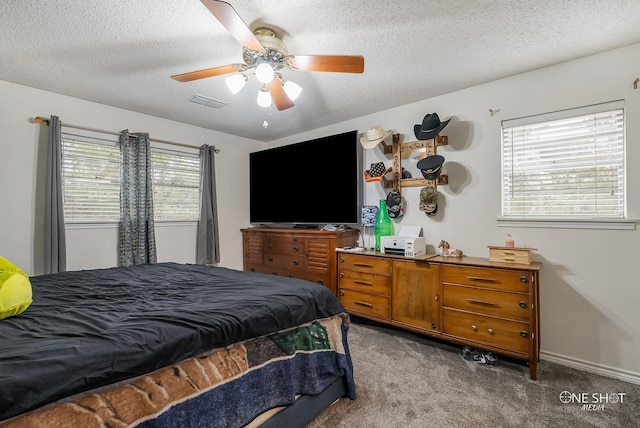 carpeted bedroom featuring a textured ceiling and ceiling fan