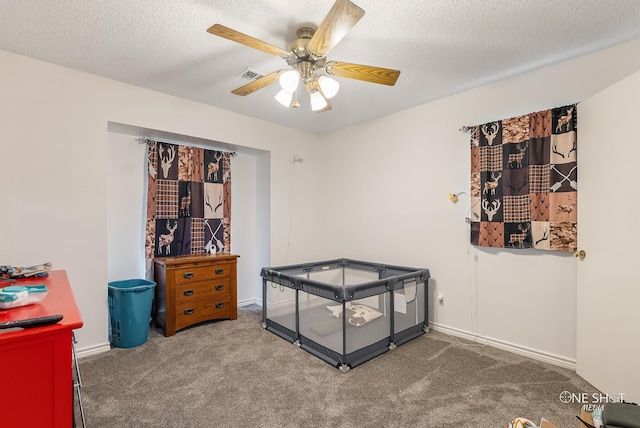 carpeted bedroom featuring a textured ceiling and ceiling fan