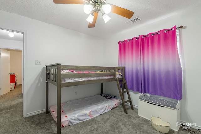 carpeted bedroom with a textured ceiling and ceiling fan