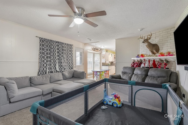 living room featuring ceiling fan, carpet floors, and a textured ceiling