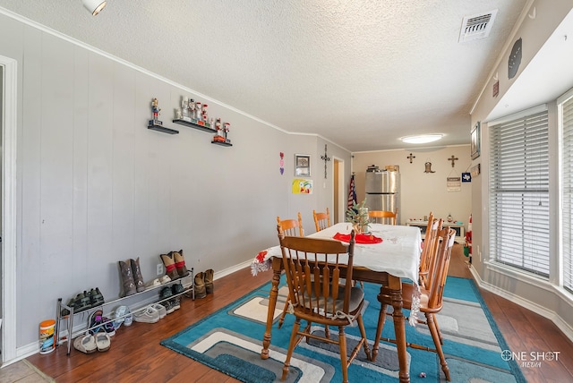 dining room with dark hardwood / wood-style floors and crown molding