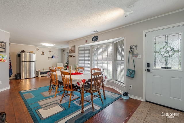 dining room featuring ornamental molding, a textured ceiling, and a wealth of natural light