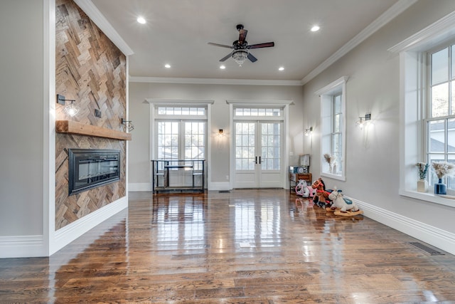 living room with hardwood / wood-style floors, ornamental molding, a tile fireplace, and french doors