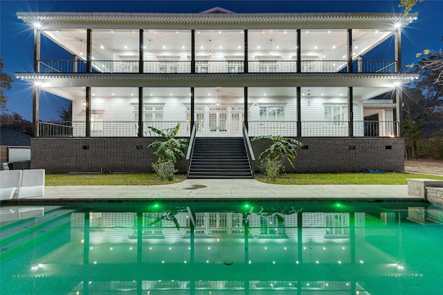 back house at night featuring a balcony