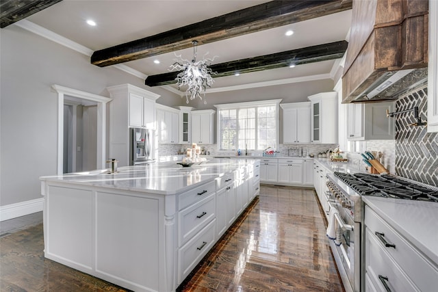 kitchen featuring beam ceiling, white cabinetry, a center island, and appliances with stainless steel finishes