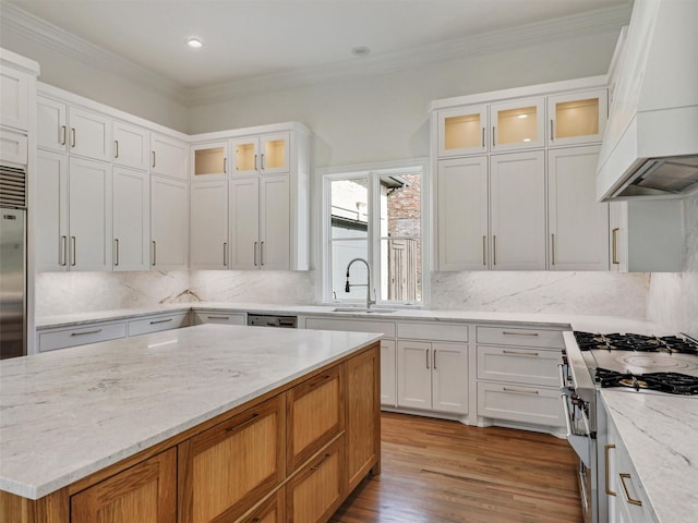 kitchen featuring white cabinetry, sink, light stone countertops, high end range, and custom range hood