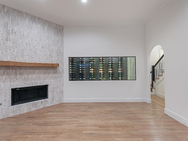 unfurnished living room with light hardwood / wood-style floors and crown molding