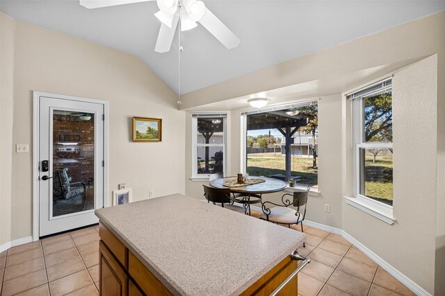 kitchen featuring vaulted ceiling, a wealth of natural light, and light tile patterned flooring