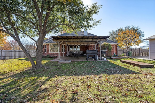 rear view of property featuring a yard, a pergola, and a patio