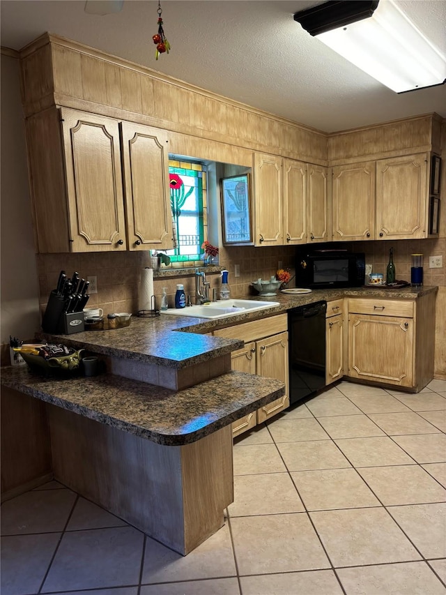 kitchen featuring backsplash, a sink, dark countertops, a peninsula, and black appliances