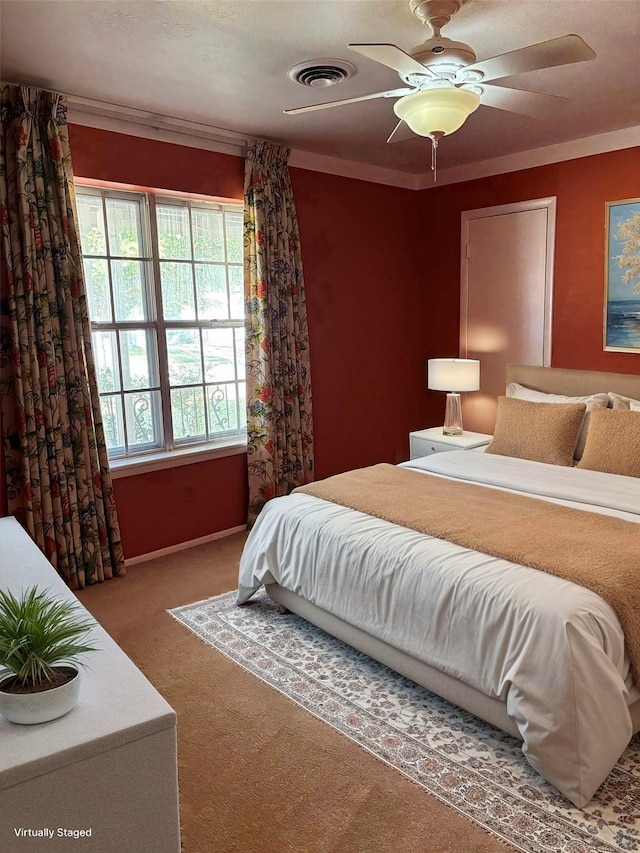carpeted bedroom featuring a ceiling fan, crown molding, and visible vents