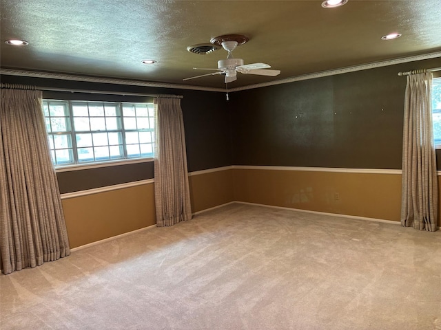 unfurnished room with carpet flooring, ornamental molding, visible vents, and a ceiling fan