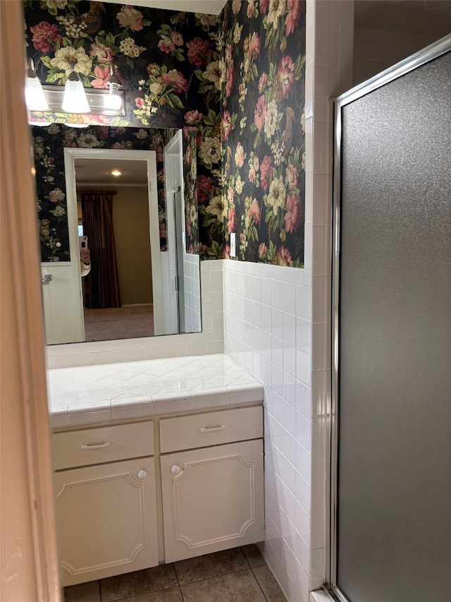 bathroom with a stall shower, wallpapered walls, tile patterned flooring, and tile walls