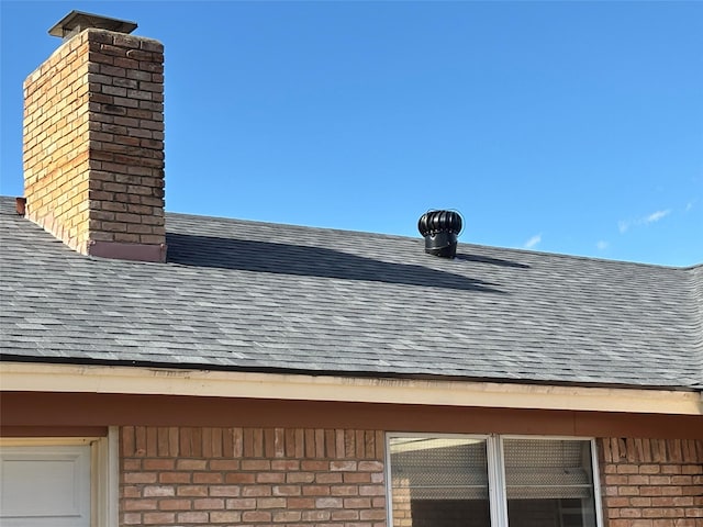 exterior details featuring brick siding, a shingled roof, and a chimney