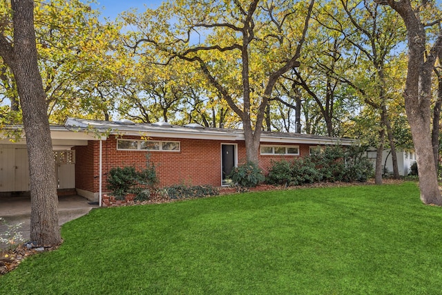 ranch-style house featuring a front lawn and a carport