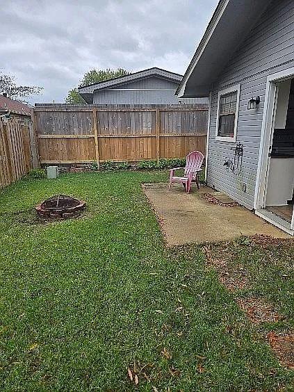 view of yard featuring an outdoor fire pit and a patio