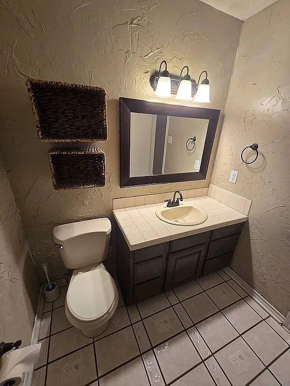 bathroom featuring tile patterned flooring, vanity, and toilet