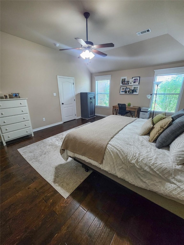 bedroom featuring dark hardwood / wood-style flooring, multiple windows, lofted ceiling, and ceiling fan