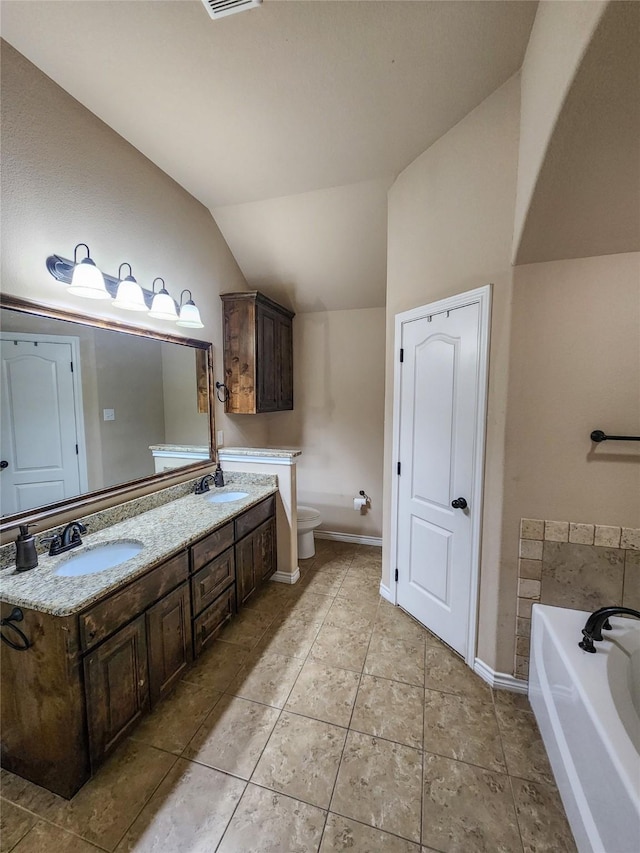 bathroom with a bathing tub, vanity, toilet, and vaulted ceiling