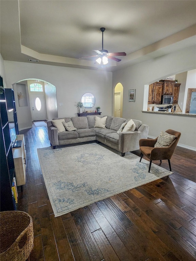 living room with dark hardwood / wood-style flooring and ceiling fan