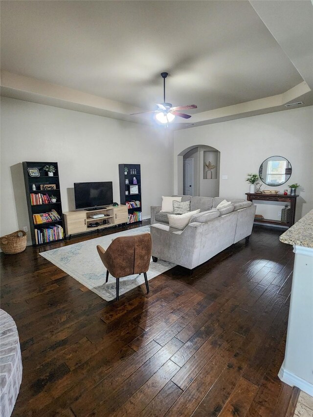 living room featuring ceiling fan and dark hardwood / wood-style flooring