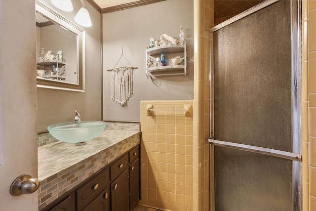 bathroom with a shower with door and vanity