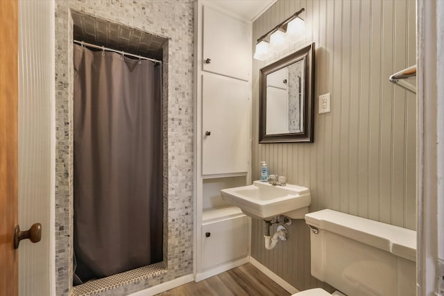 bathroom with sink, hardwood / wood-style floors, curtained shower, and toilet