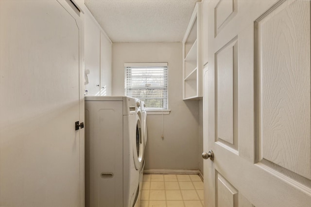 washroom with washer and dryer, cabinets, and a textured ceiling