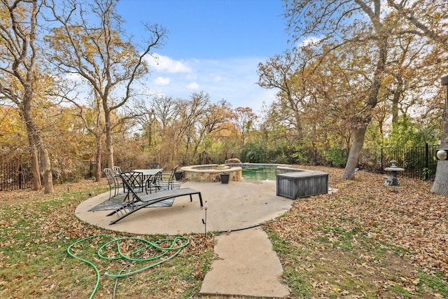 view of yard featuring a swimming pool with hot tub and a patio area