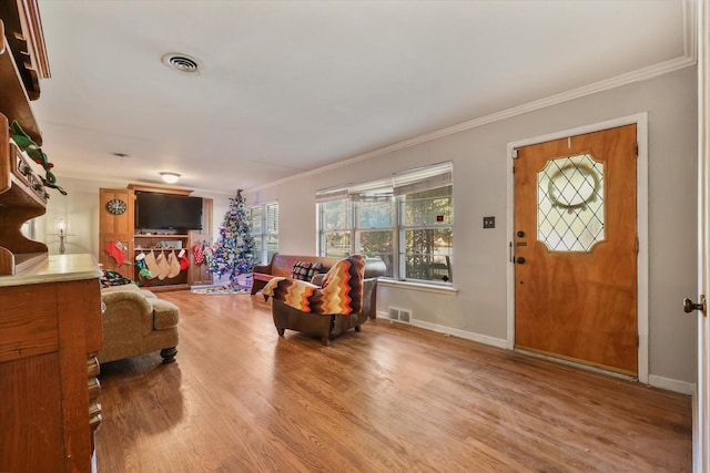 entrance foyer with crown molding and wood-type flooring